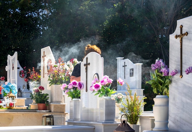 Graves in the Greek cemetery decorated with flowers and vases in Greece