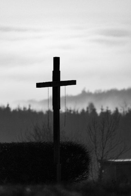 Photo graveyard cross in front of misty forests