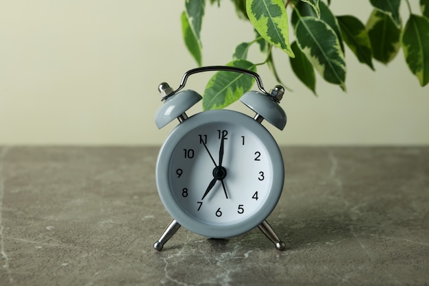 Gray alarm clock on gray textured table