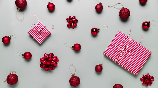 Gray background with two pink Christmas gift boxes red ball toys spheres bows