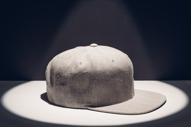 Photo gray baseball cap in a round spot of light