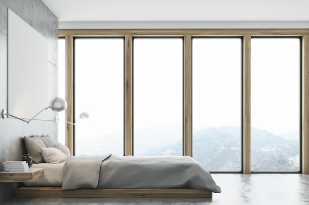 Gray bedroom interior with a panoramic window, a double bed standing along it and a large horizontal poster hanging above. A home office is in the background. Front view. 3d rendering, mock up