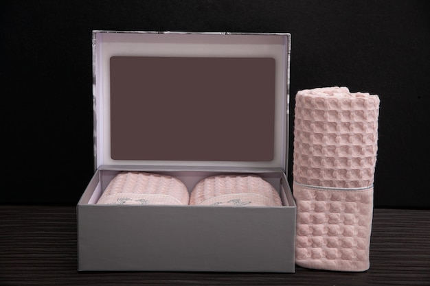 Gray box with pink towels on dark.