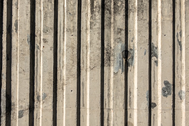 Gray cement wall with vertical lines and shadow