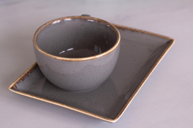 Photo gray clay coffee cup with saucer on the table