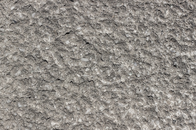小さな白い石と灰色のコンクリートの背景。