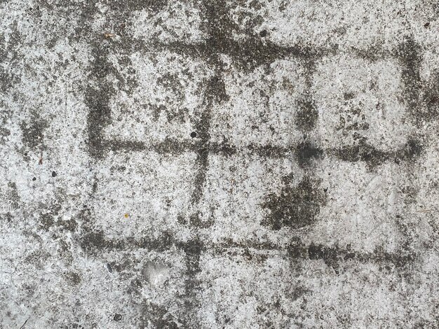 A gray concrete surface with a cross in the middle.