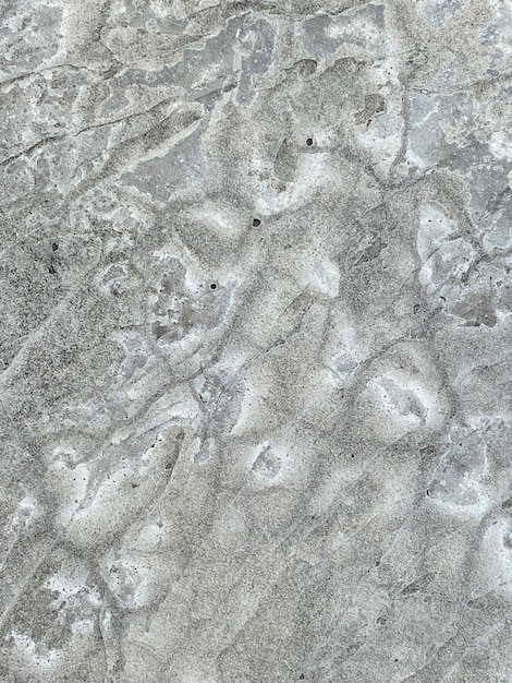 A gray concrete wall with a pattern of rocks and rocks