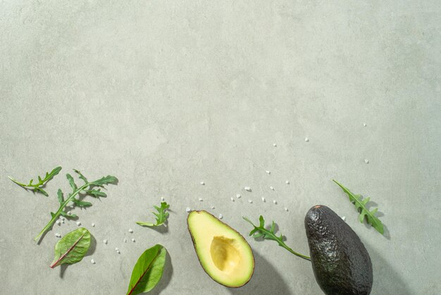Фото Серый кулинарный фон с салатами и авокадо.
