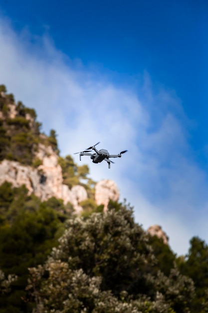 Gray drone flying over rural landscape