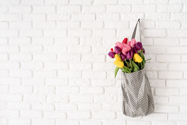 Gray fabric bag full of colorful tulips