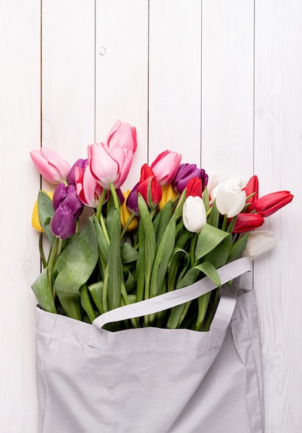 Gray fabric bag full of colorful tulips