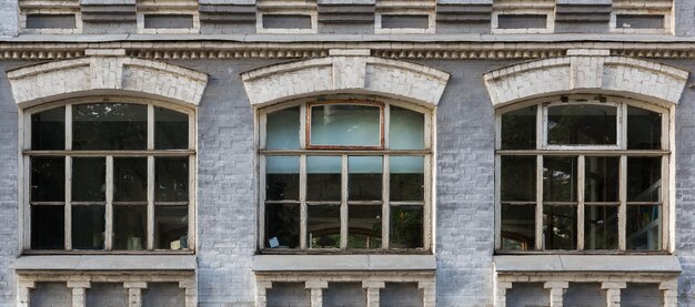 Gray facade of a historic building with three arched windows