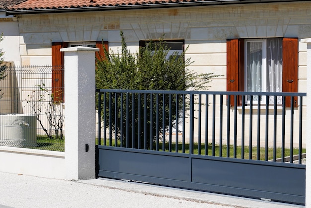 Cancello grigio della classica casa unifamiliare in una strada suburbana