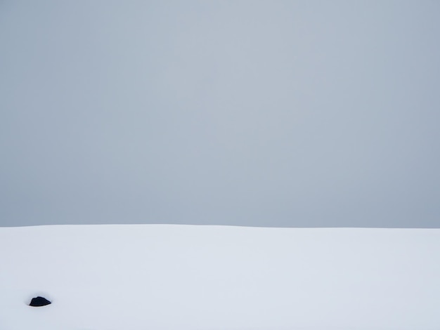 Gray gradient, snowdrift on a gray sky background. Snowy surface, abstract background.