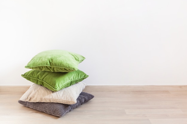 Gray and green pillows on the floor