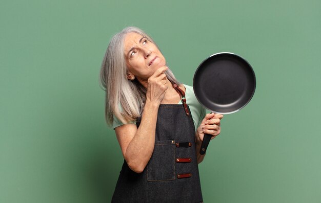 gray hair pretty middle age chef woman with a pan