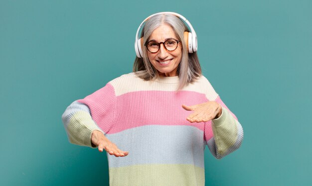 Bella donna dai capelli grigi che ascolta musica con le sue cuffie