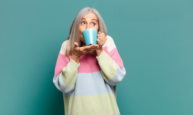 コーヒーやお茶と白髪のきれいな女性