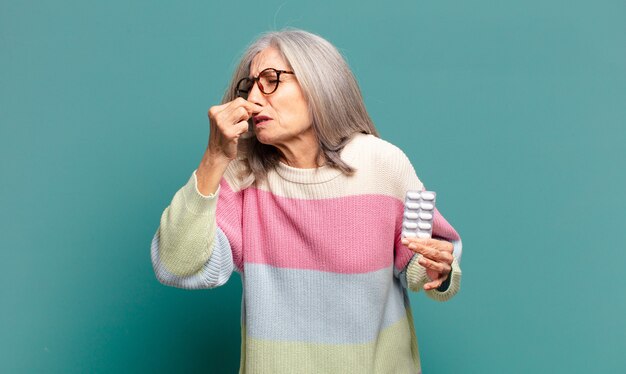 질병 약을 가진 회색 머리 예쁜 여자