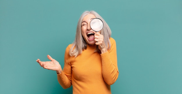 Gray hair pretty woman with a magnifying glass