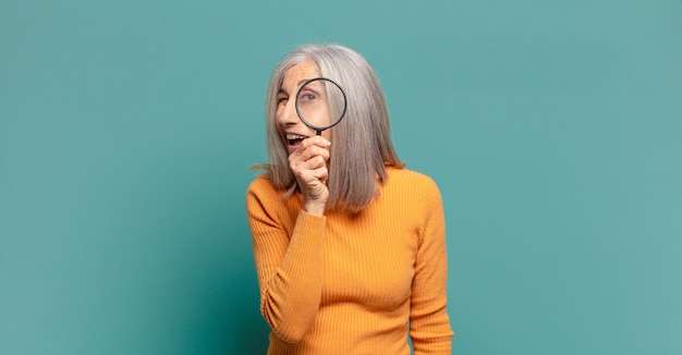 Gray hair pretty woman with a magnifying glass