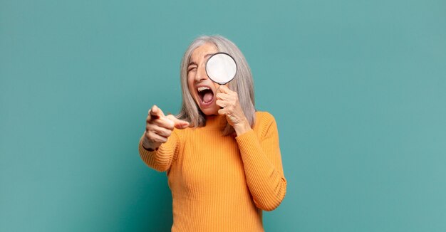 Gray hair pretty woman with a magnifying glass