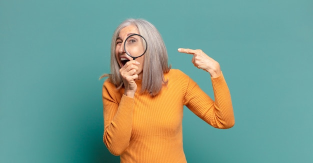 Gray hair pretty woman with a magnifying glass