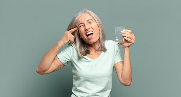 Bella donna dai capelli grigi con marijuana