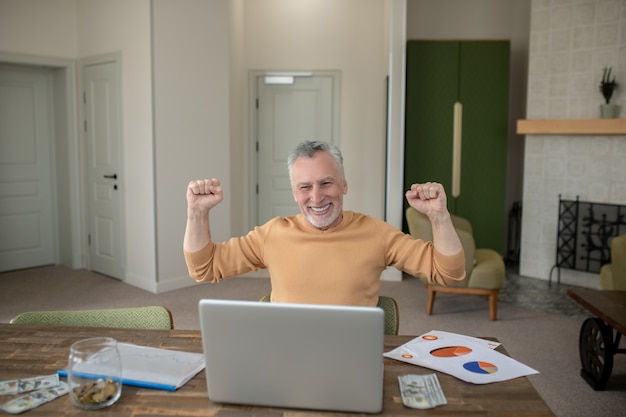 Gray-haired man in casual clothes working from home