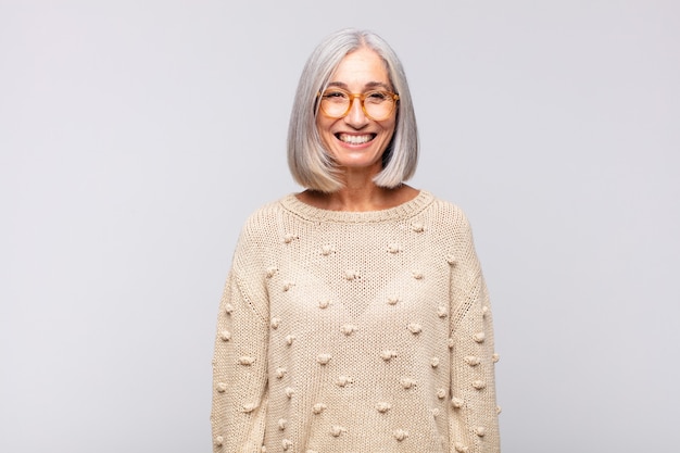 Gray haired woman with a big, friendly, carefree smile, looking positive, relaxed and happy, chilling