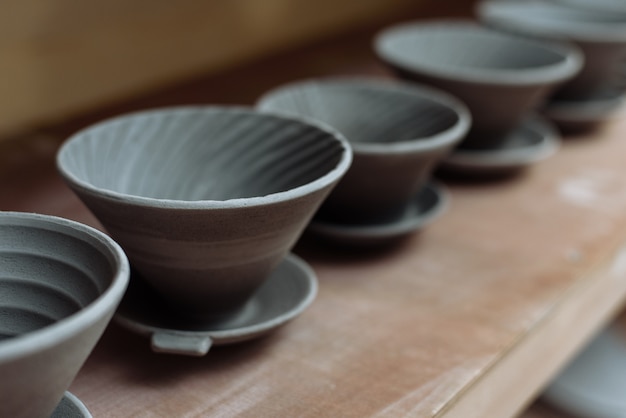 Gray handmade ceramic plates. Glazed clay plates in a pottery workshop.