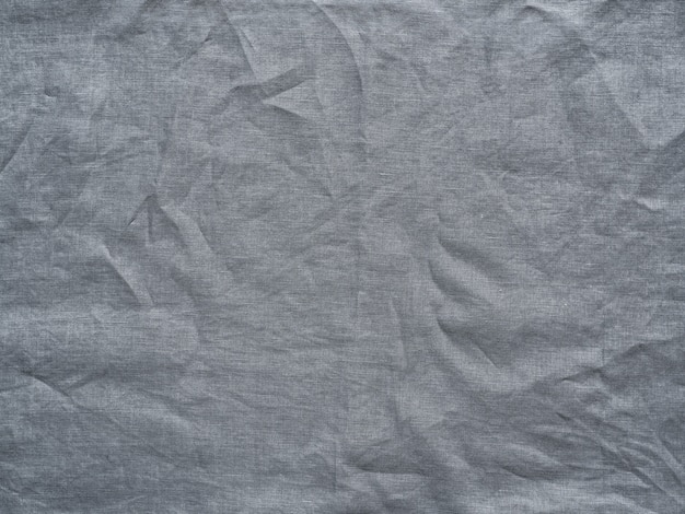 Gray linen texture as background. Gray linen crumpled tablecloth. 