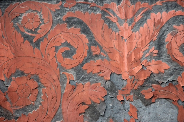 Gray and orange teracotta fresco ornament on ancient wall in Victorian style