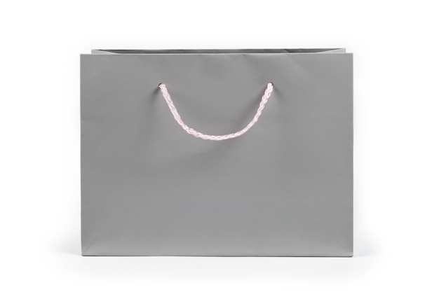 Gray paper shopping bag on light background. Free space for text. Shopping, sale, surprise or gift concept.