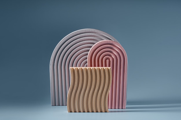 Gray and pink arches and wooden plate with waves  on a blue background