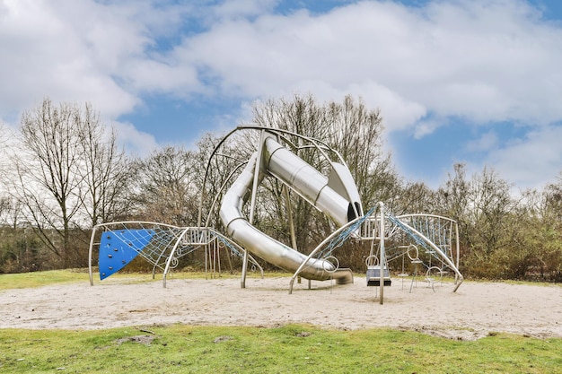 Foto parco giochi grigio sul cortile nel parco in una giornata nuvolosa