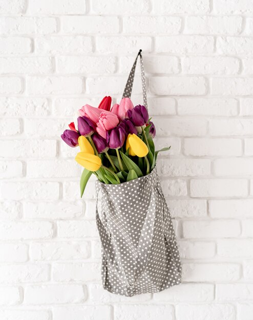 Gray polka dot fabric bag full of colorful tulips