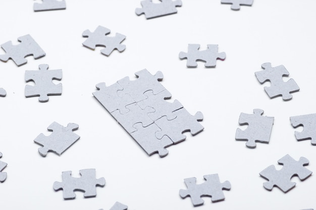 Pezzi di puzzle grigi isolati su bianco