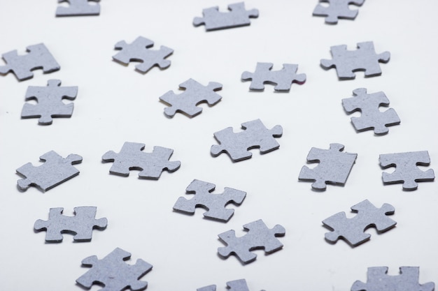 Pezzi di puzzle grigi isolati su bianco