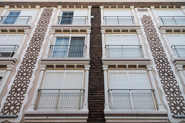 Серый жилой дом с плоскими одинаковыми балконами с рваными кондиционерами Балконный узор