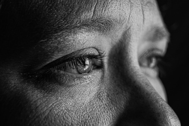 Gray-scale closeup of the eyes of a woman with tears in her eyes