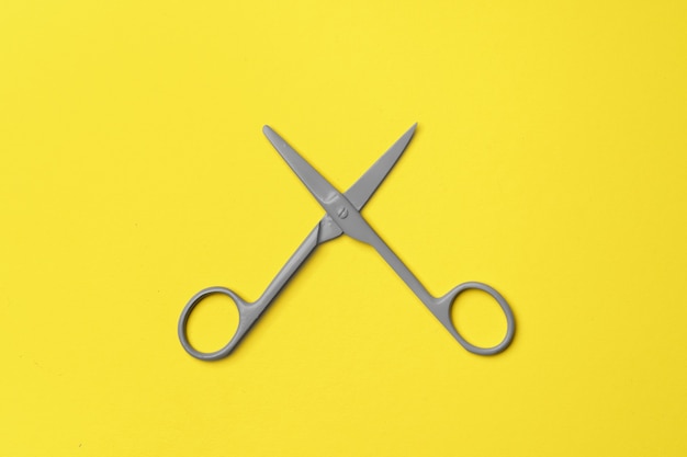 Gray scissors on yellow