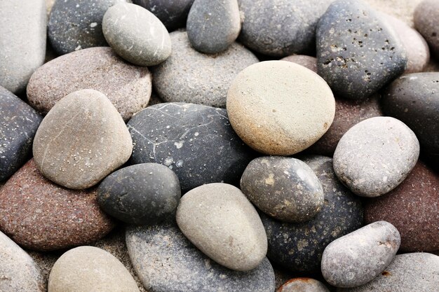 Gray sea pebbles on sand background