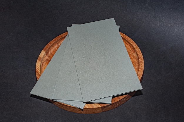 Gray, silver envelopes on a wooden round plate, luxury\
corporate identity and corporate identity design for layouts