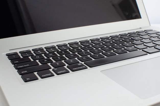 Gray or silver laptop on table with black keys keyboard with
letters numbers and symbols computer.