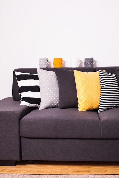 Gray sofa with many colorful pillows on it