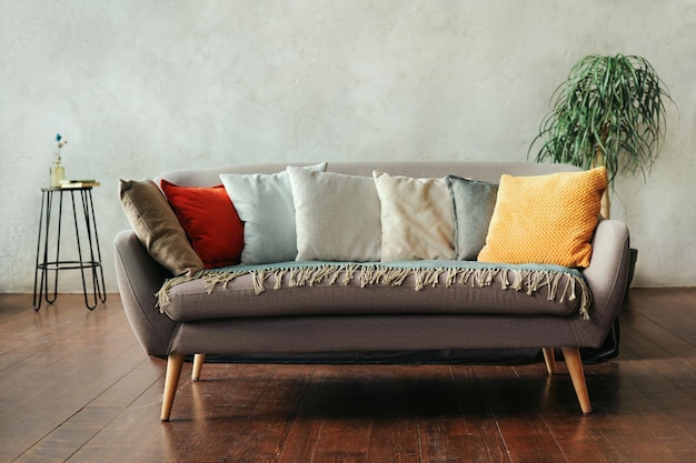 Gray sofa with pillows of different colors in a modern living room interior