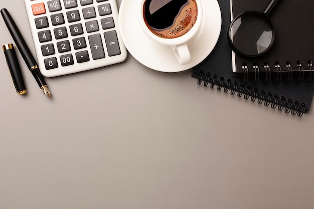 Gray stylish workplace with smartphone and office supplies on black leather table background