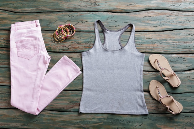 Gray tank top and pants. Light pink trousers and footwear. Summer outfit with simple top. Discounted goods in brand store.